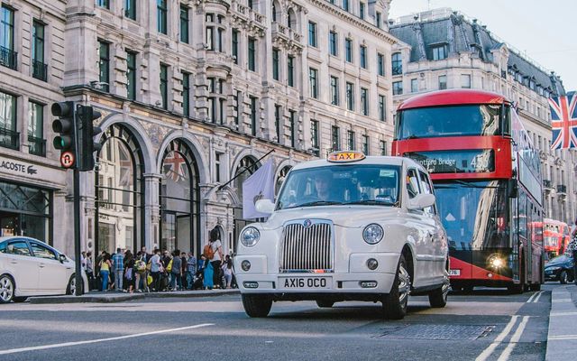 Regent Street in London with Union Jack flags and a red double-decker bus